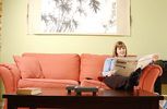 Woman reading newspaper in living room.jpg