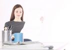 Woman sitting and reading newspaper at desk c103114.jpg