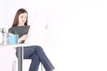 Woman sitting and reading newspaper at desk.jpg