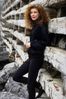Woman standing against wooden supports.jpg