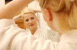 Woman trying hairstyle in bathroom mirror.jpg