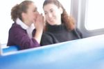 Woman whispering secret to her friend.jpg